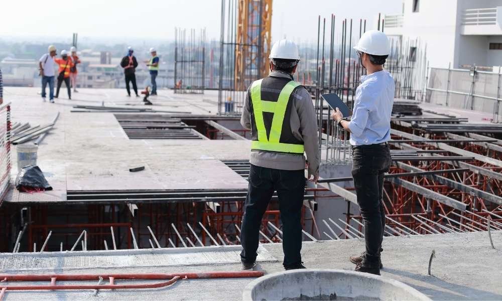 Construction workers on building site with equipment.