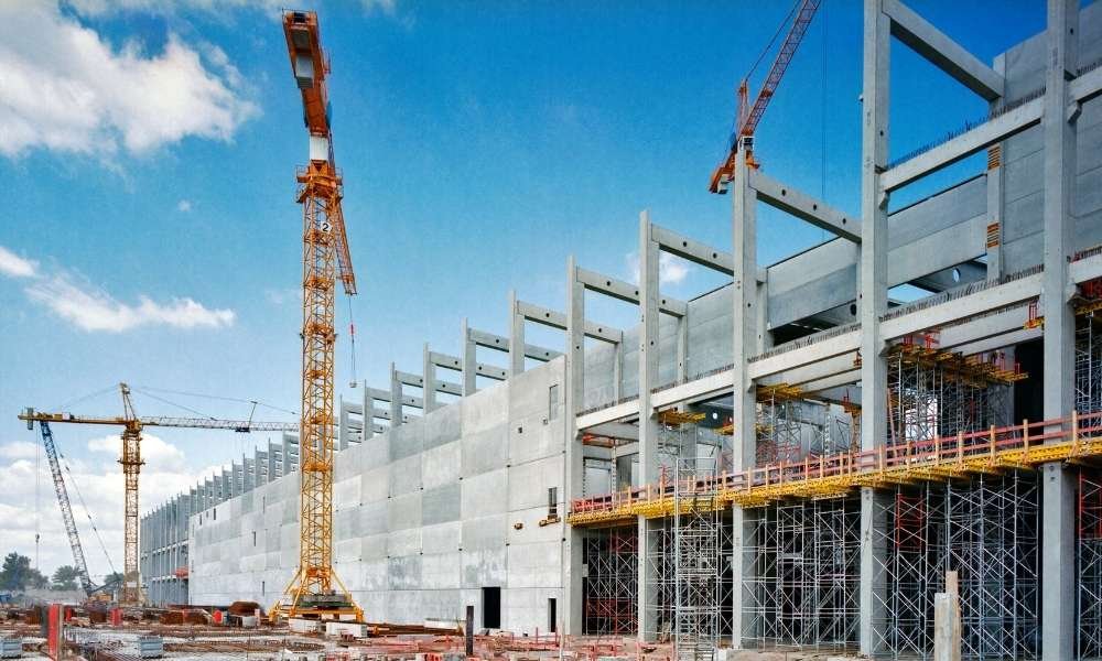Industrial building under construction with cranes.