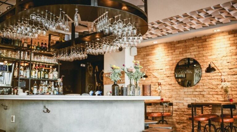 Cozy bar interior with hanging glasses and flowers.