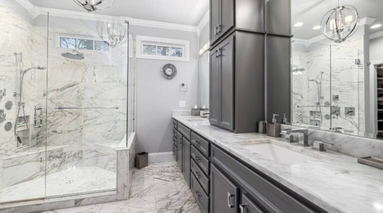 Elegant modern bathroom with marble surfaces and glass shower.