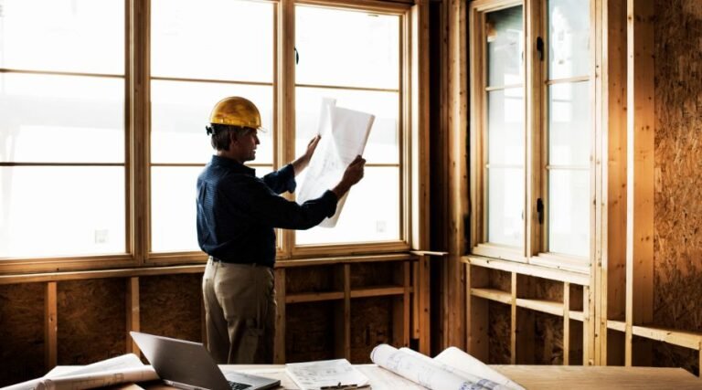 Architect reviewing blueprints in a construction site.