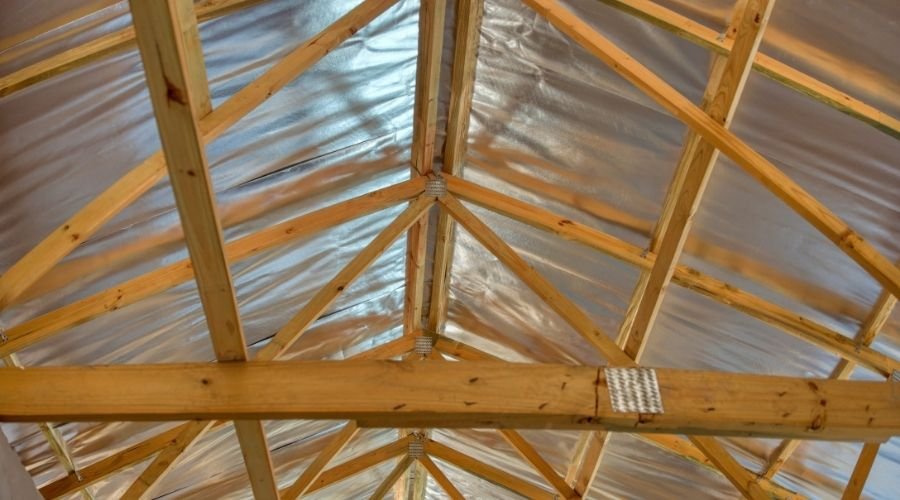 Wooden roof trusses with insulation foil.