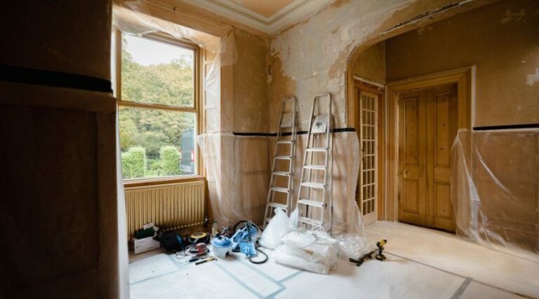 Room under renovation with ladders and tools.